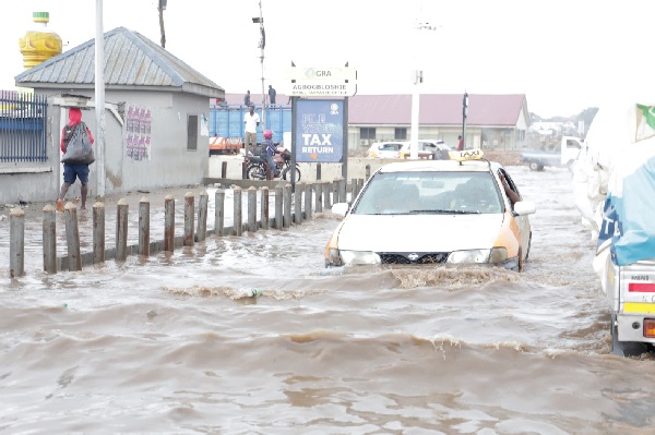 A taxi making its way through the flooded road at Agbogbloshie